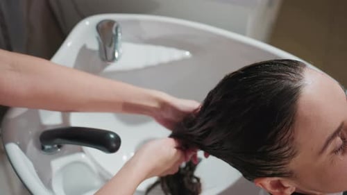 Salon Shampoo Session Client Receiving Scalp Massage Relaxing Hair Treatment at Salon Basin