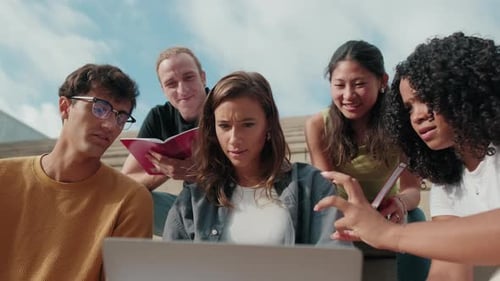 Friendly group of multiracial high-school students using computer technology. Side view