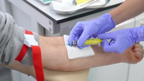 Medical Professional Drawing Blood Sample with Syringe