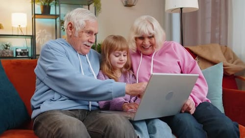 Grandparents and Grandchild Using Laptop Together at Home