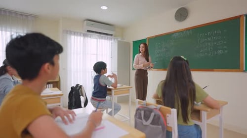 Group of students learning with teacher in classroom at elementary school.