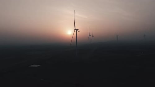 Wind Turbines at Twilight with Golden Hour Light Aerial View of Wind Farm for Renewable Energy