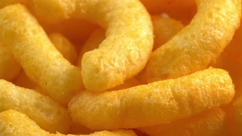 Cheesy Corn Sticks drehen sich in Nahaufnahme. Knuspriger Käsesnack. Knusprige, flauschige Maischips
zum Frühstück