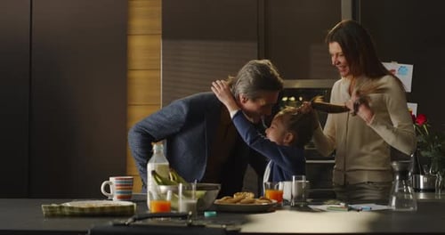 Happy Family Portrait: Father Kissing Mother and Daughter B