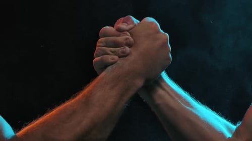 Arm Wrestle Match Under Red and Blue Lights