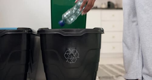 Hand Recycling in Kitchen Trash Bin Close Up
