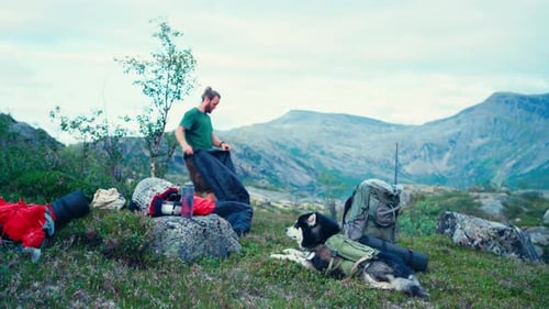 Man Setting Up A Tent On A Camping Trip In Rago National Park, Norway - Wide Shot