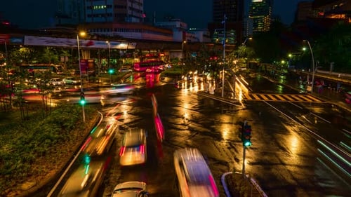 Dusk-to-night timelapse of modern Asian city intersection. Car light trails, urban lights, neon.