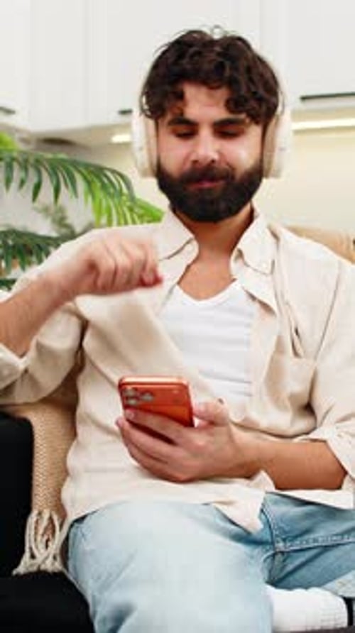 Man Listening to Music on Headphones Indoors