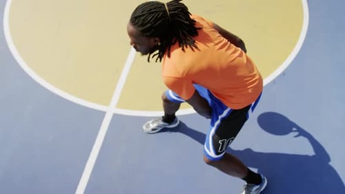 Skilled Athlete Dribbles Basketball on Outdoor Court