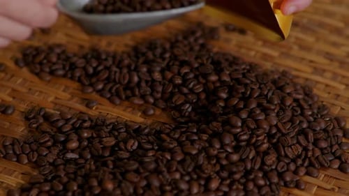 Closeup macro of pour roasted coffee green beans into stoarge prepare to put in packaging