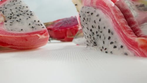 Pitahaya or dragon fruit with white flesh, I cut a piece with a knife. Super close-up.