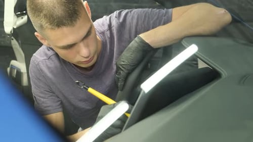 Young Adult Man Working on Car Interior