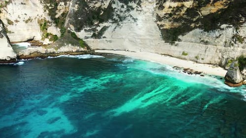 Aerial drone view of Atuh Beach in Nusa Penida, Bali, Indonesia. Turquoise water reveals coral reef