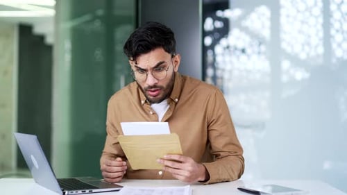 Man Reading Letter with Negative News at Office