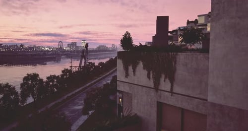 Colorida puesta de sol reflejándose en un río con edificios modernos en el fondo