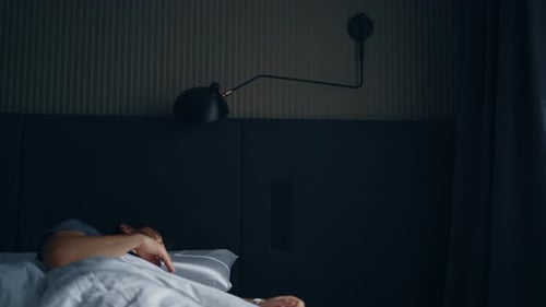 Un homme d'âge moyen de race blanche barbu se réveille dans son lit avec des douleurs au cou et au dos