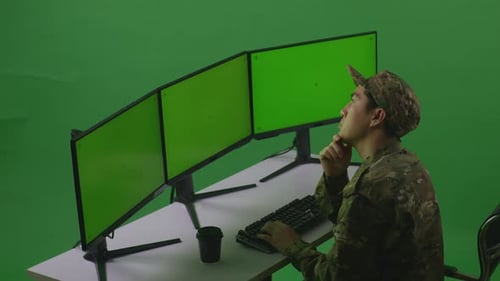 Side View Of Man Soldier Thinking While Working With Mock Up Multiple Monitor In Green Screen