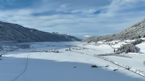 Small winter village covered by fresh snow and partly foggy weather.