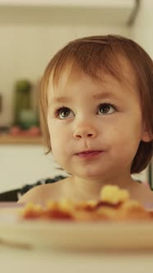 Child Eats Food at Home with a Fork