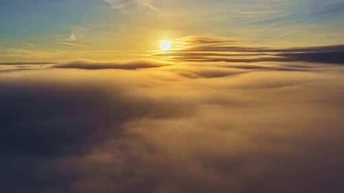 Scenic view of a sunrise over a sea of clouds above high altitude skyline