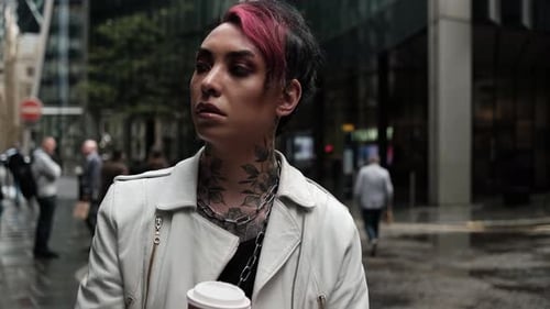 Persona andrógina esperando impaciente con una taza de café en la calle.