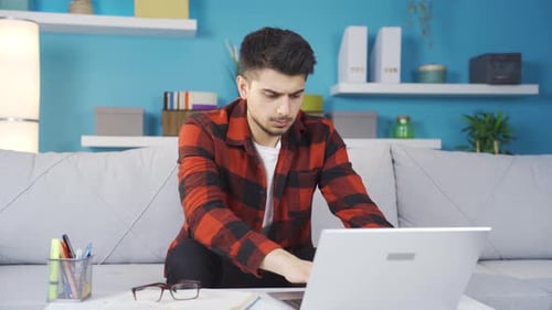 Young Adult Works on Laptop at Home