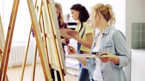 Art School, Creativity and People Concept - Group of Students with Easels