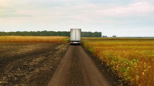 Long Haul Semi Trucks Driving in the field in the Rural Region
