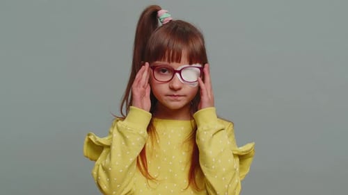 Young Girl Wearing Eye Patch and Glasses