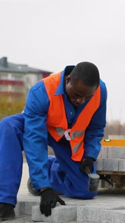 Construction Worker Laying Paving Blocks on Urban Sidewalk