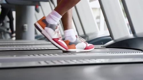 Young Black Guy Running on Treadmill at Gym Close Up of Legs