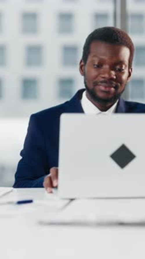 Happy Black Male Worker in Modern Office Opening Laptop in Workplace Vertical Video Portrait