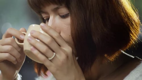 Closeup of a Caucasian Girl Drinking Coffee in a Cafe