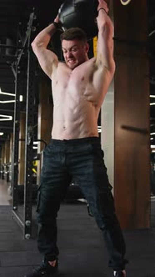 Workout routine in gym. Young handsome man doing exercises in the gym