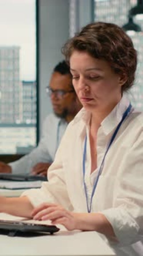 Woman Puts On Headphones at Office Desk