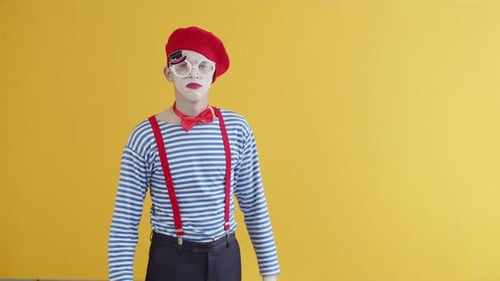Porträt einer Pantomime, die auf gelbem Hintergrund eine lustige Aufführung spielt