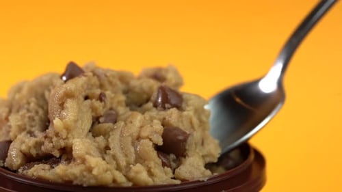 Picking up a spoonful of raw chip cookie dough