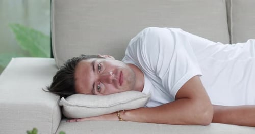 Depressed Anxious Worried Young Male Feeling Bad Upset Sad Insecure Man Lying Alone at Home on Sofa