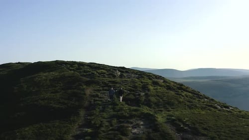 Aerial view of couple hiking mountains summer. Hikers walking. Sports recreation activity. Summer ho