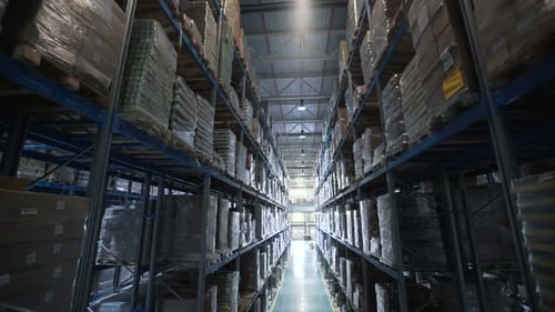 Large Warehouse Logistics Terminal. Camera Moves Up On Shelves Of Cardboard Boxes Inside A Storag...