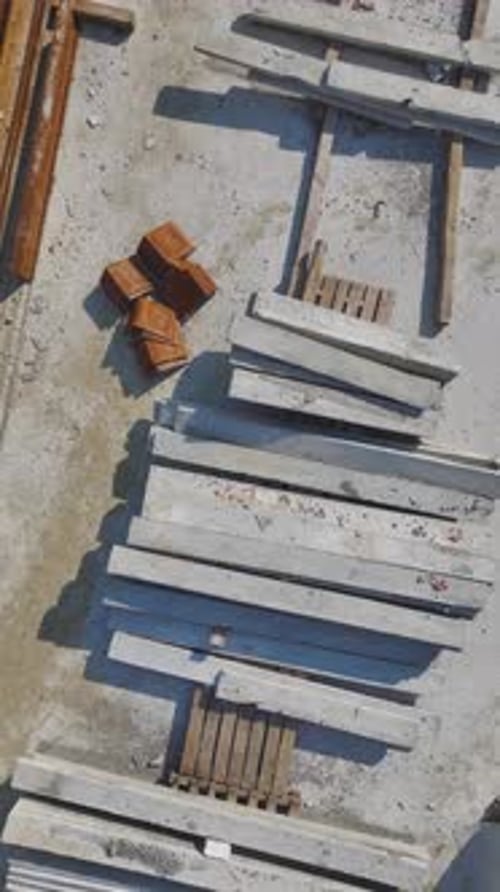 Vídeo vertical: trabajadores de la construcción colaboran activamente en la construcción de paredes, hormigón y metalistería