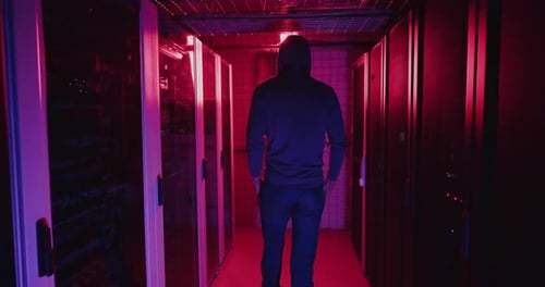 Person Walking Through a Dark Server Room