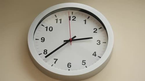 Static Shot of a Round Wall Clock on the Light Wall