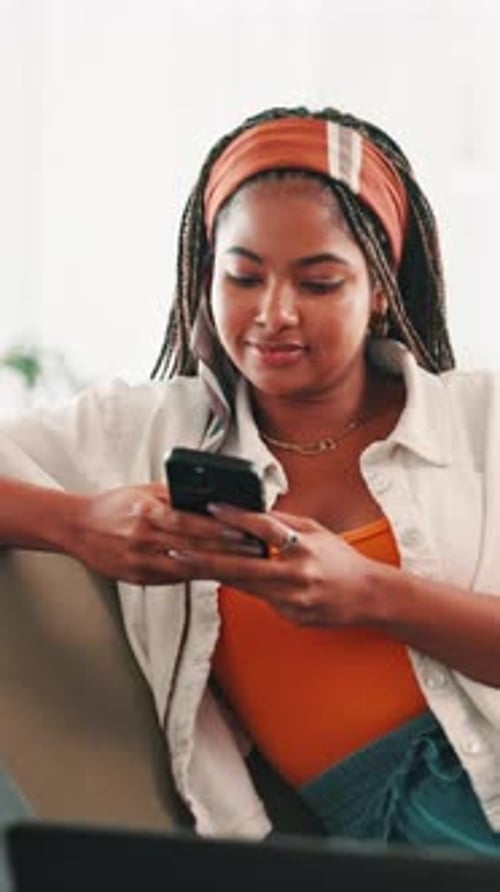 Smiling Young Woman Uses Phone Indoors