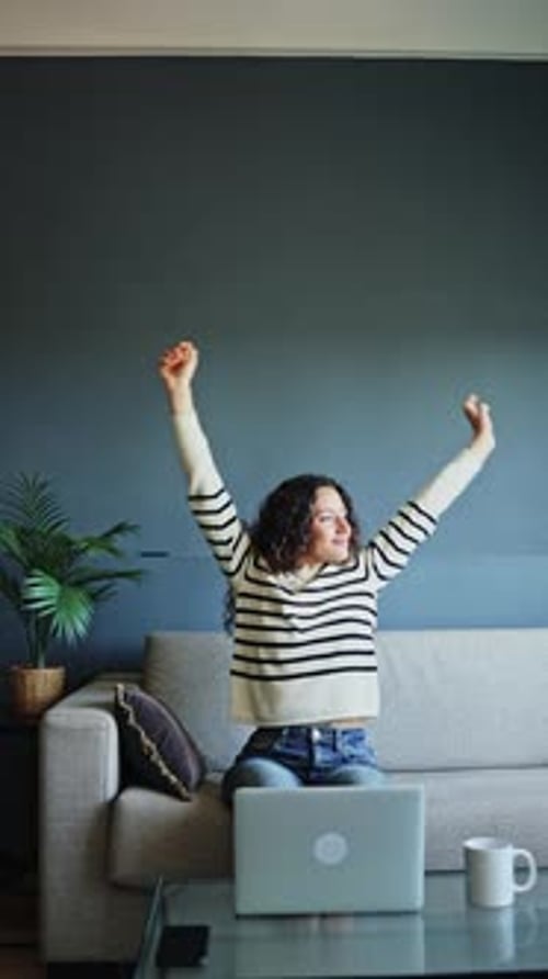 Woman Working on Laptop Stretches at Home