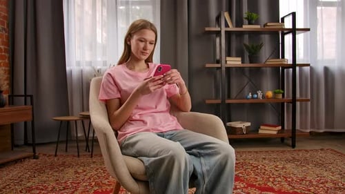 Young Woman Using Cell Phone, Sitting in Chair