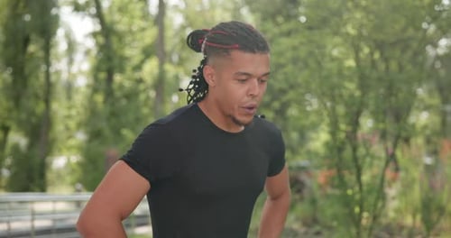 Tired African American Athlete Restores Breathing and Rests After Jogging Outdoors