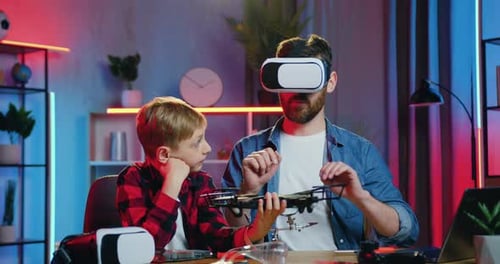 Father and Son Examining Drone with VR Headset