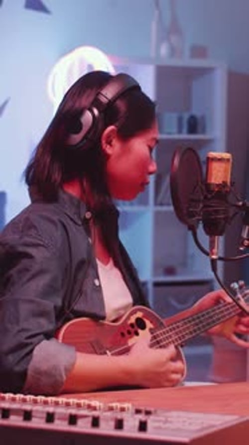 Asian Woman Playing Ukulele and Singing in Mic in Home Recording Studio